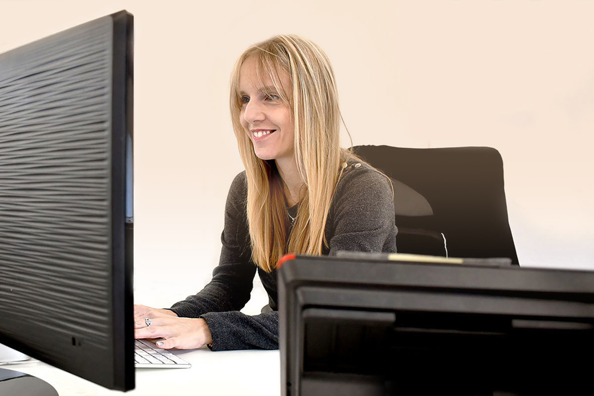 Woman typing on desktop computer
